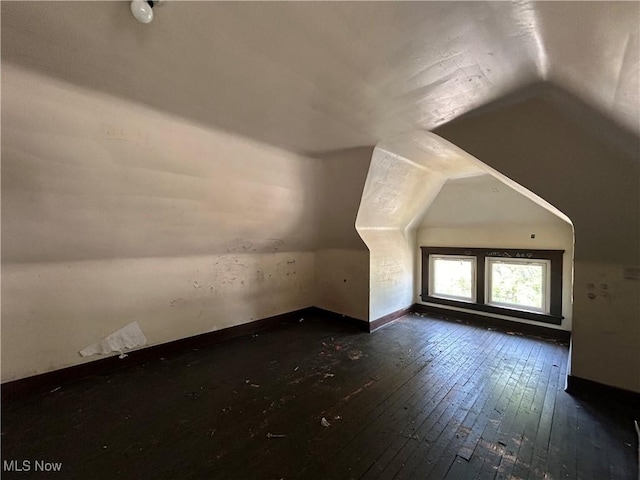 additional living space with dark hardwood / wood-style floors and lofted ceiling