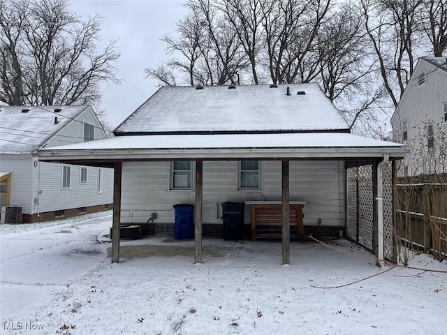 snow covered house featuring central AC unit