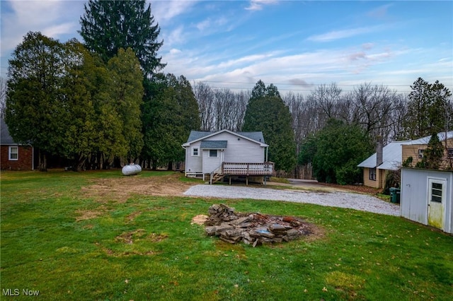 view of yard featuring a deck and a fire pit