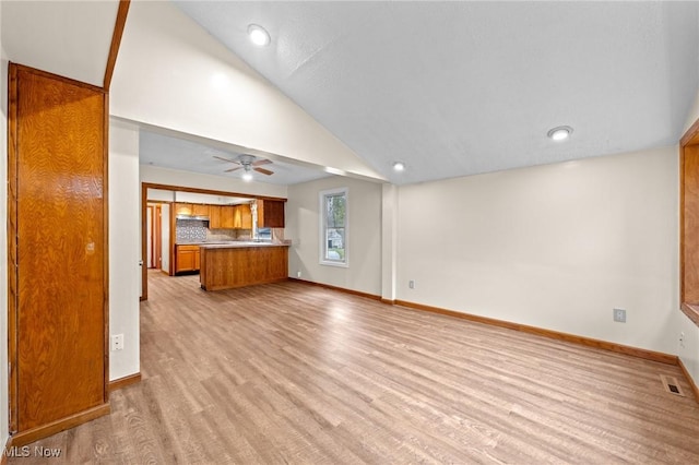 unfurnished living room featuring light hardwood / wood-style flooring, ceiling fan, and lofted ceiling