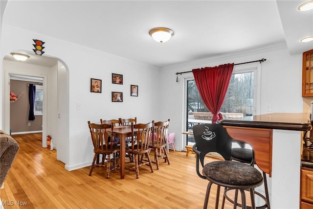 dining area with light hardwood / wood-style flooring and ornamental molding