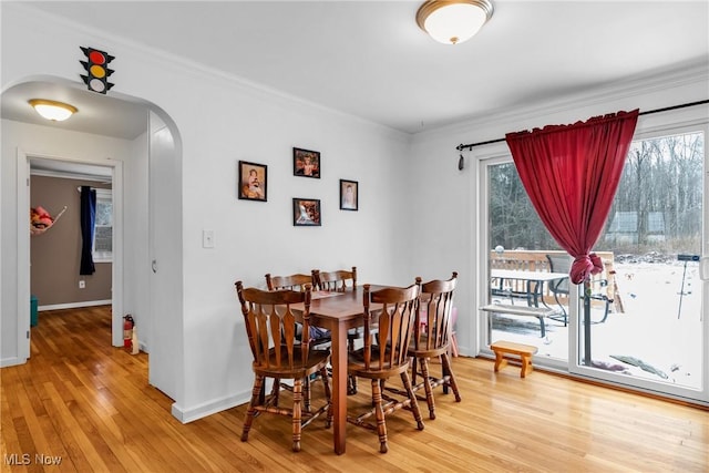 dining space featuring hardwood / wood-style floors and crown molding