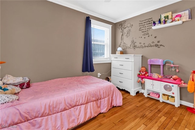 bedroom featuring ornamental molding and light hardwood / wood-style flooring