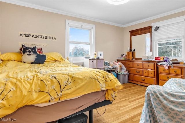 bedroom featuring light wood-type flooring and crown molding