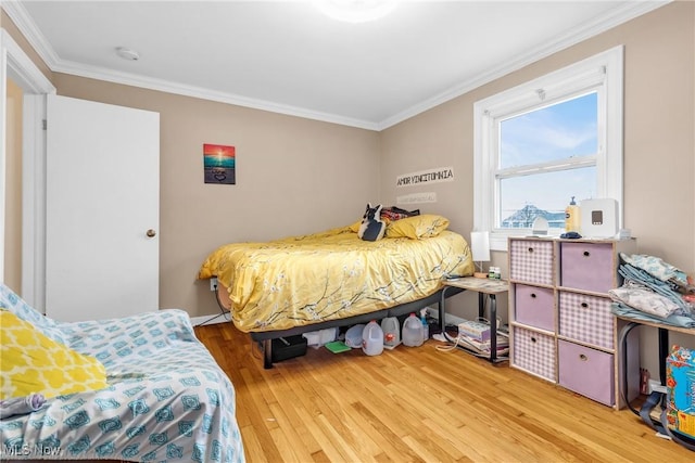 bedroom featuring crown molding and light wood-type flooring