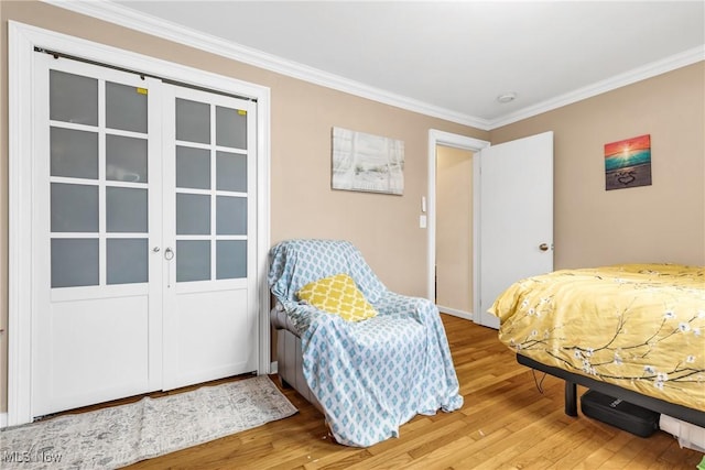 bedroom with crown molding and wood-type flooring