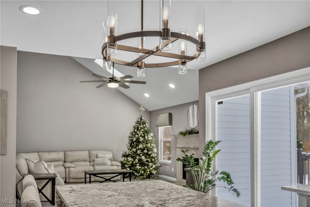 living room featuring ceiling fan with notable chandelier and lofted ceiling