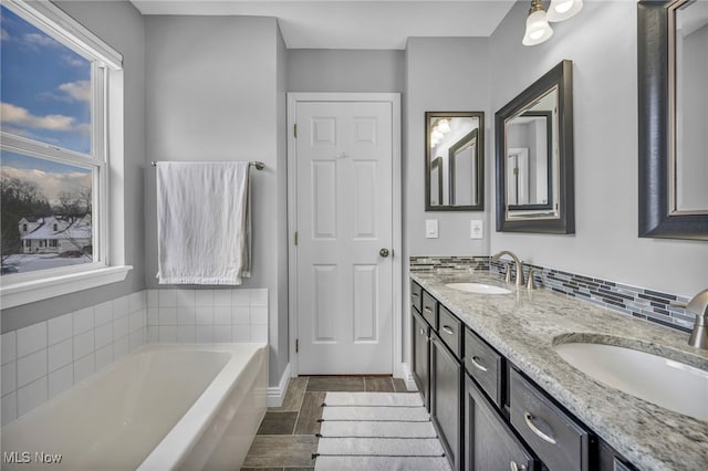 bathroom with vanity and tiled tub