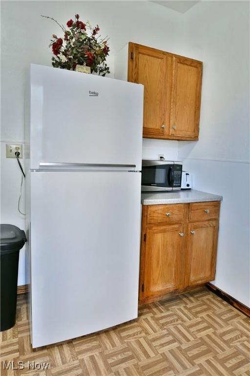 kitchen featuring light parquet flooring and white fridge