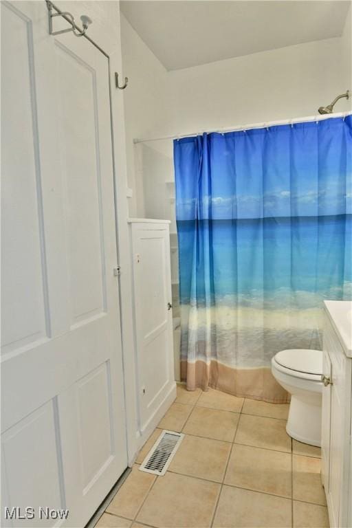 full bathroom with tile patterned flooring, vanity, shower / tub combo, and toilet