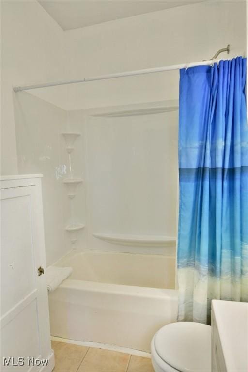 bathroom with tile patterned flooring, shower / bath combination with curtain, and toilet