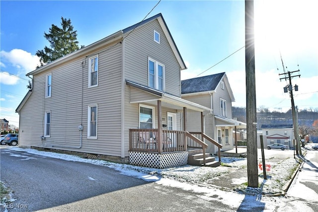 view of snow covered exterior with covered porch