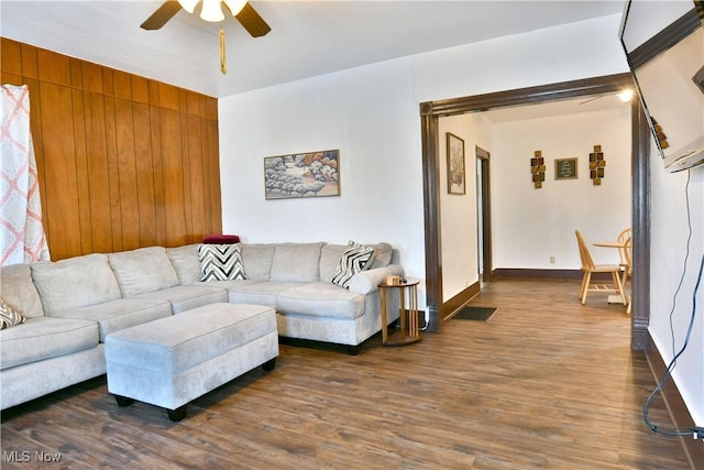 living room with ceiling fan and dark hardwood / wood-style flooring