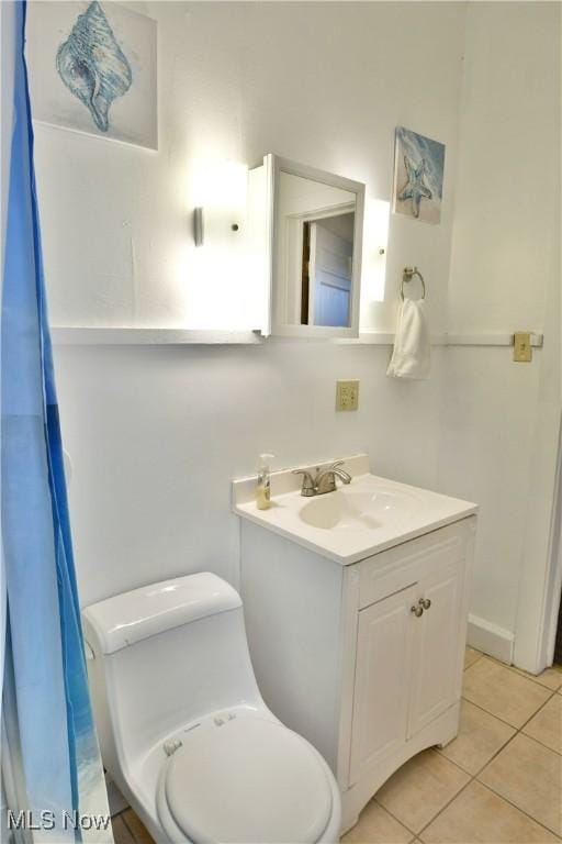 bathroom with tile patterned flooring, vanity, and toilet