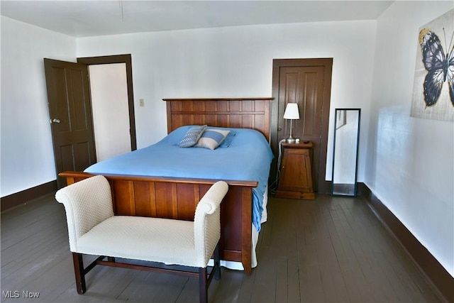 bedroom with dark hardwood / wood-style flooring