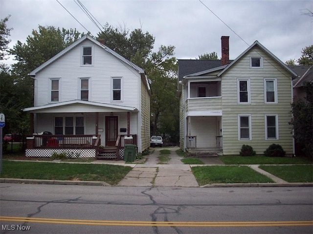 front of property with covered porch and a front lawn