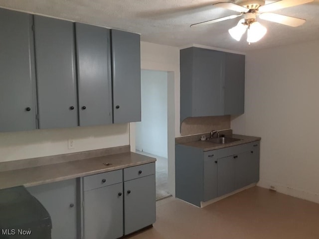 kitchen featuring gray cabinetry, ceiling fan, and sink