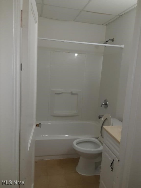 full bathroom with washtub / shower combination, a paneled ceiling, vanity, tile patterned flooring, and toilet