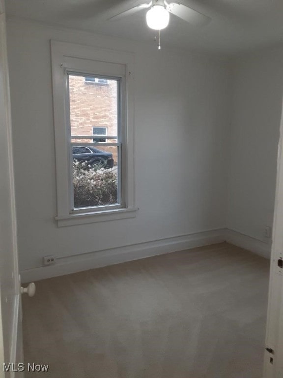 carpeted spare room with ceiling fan