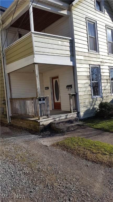 doorway to property featuring covered porch and a balcony