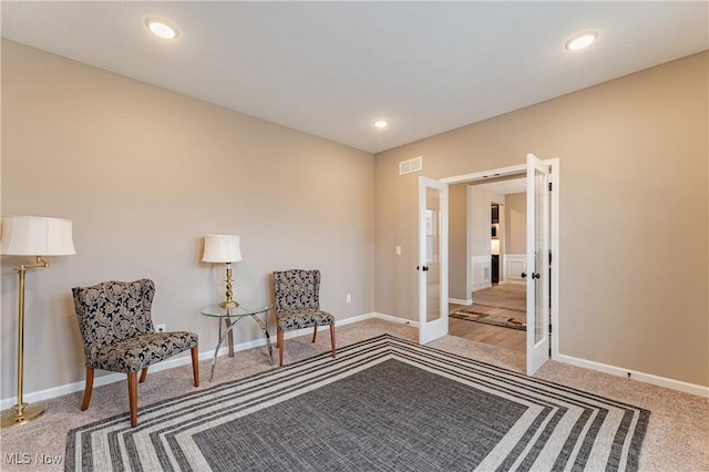 sitting room with carpet and french doors