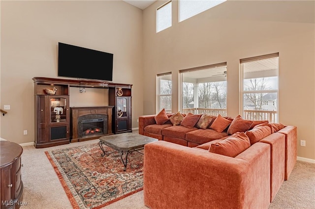 carpeted living room with ceiling fan, high vaulted ceiling, and a healthy amount of sunlight