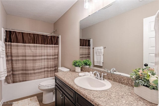 full bathroom featuring vanity, shower / bath combination with curtain, hardwood / wood-style flooring, toilet, and a textured ceiling