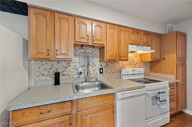 kitchen with hardwood / wood-style flooring, backsplash, white appliances, and sink