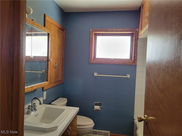 bathroom featuring vanity, toilet, and a wealth of natural light