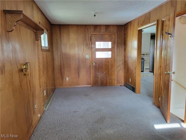 spare room with wood walls and light colored carpet