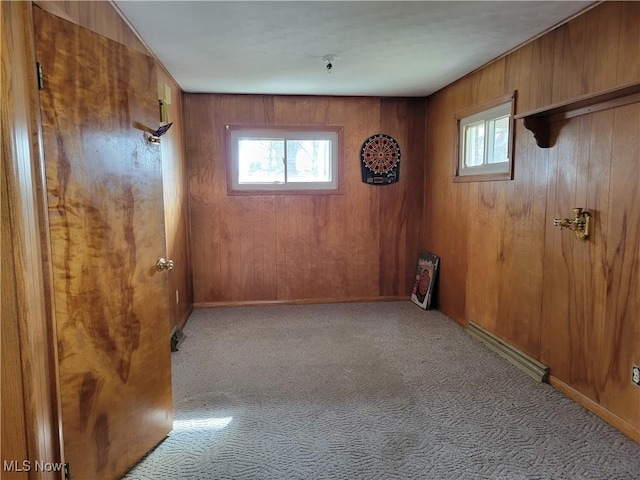 carpeted empty room featuring wooden walls