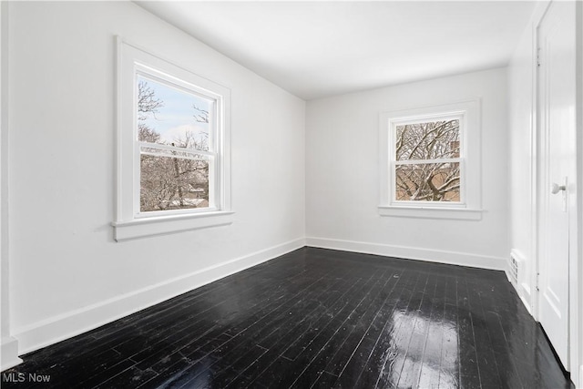 unfurnished room with dark hardwood / wood-style flooring