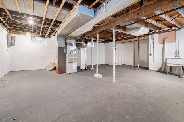 basement featuring heating unit, sink, electric panel, and water heater