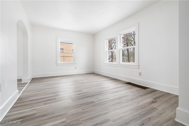 empty room with light hardwood / wood-style flooring and a healthy amount of sunlight