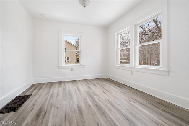 spare room featuring a healthy amount of sunlight and light wood-type flooring