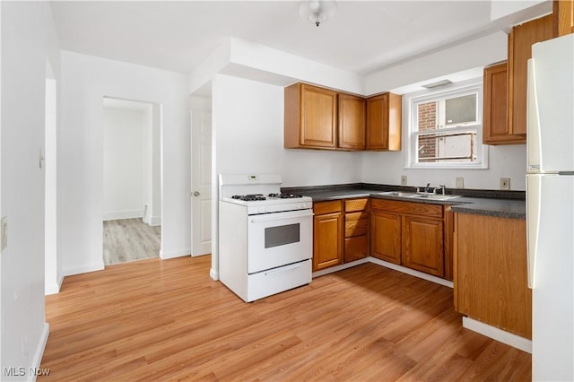 kitchen featuring sink, white appliances, and light wood-type flooring