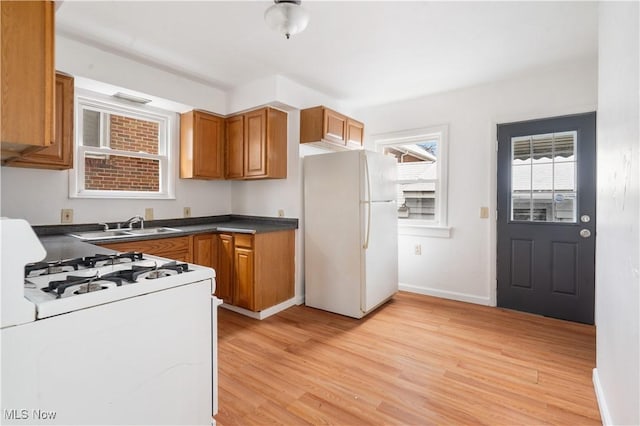 kitchen with white appliances, light hardwood / wood-style floors, and sink