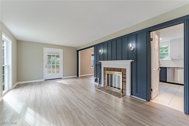 unfurnished living room featuring light wood-type flooring and a fireplace