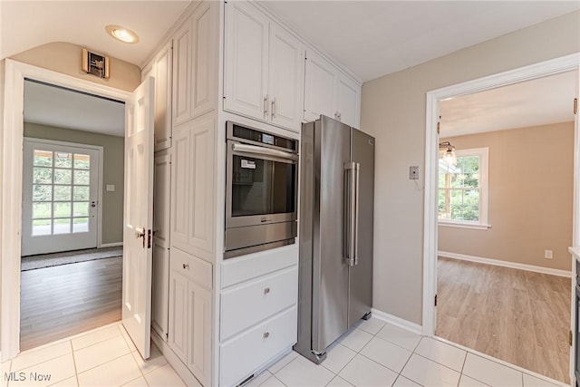 kitchen featuring plenty of natural light, light tile patterned flooring, white cabinetry, and appliances with stainless steel finishes