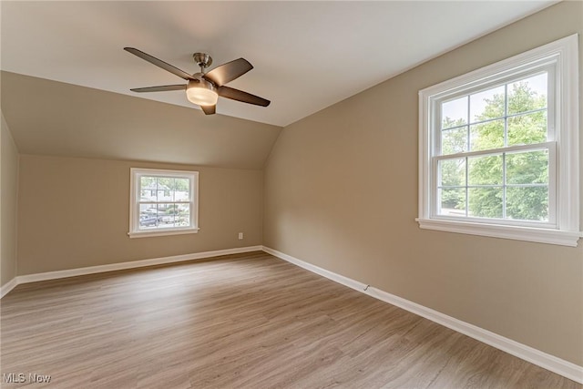 additional living space featuring light hardwood / wood-style flooring, vaulted ceiling, plenty of natural light, and ceiling fan