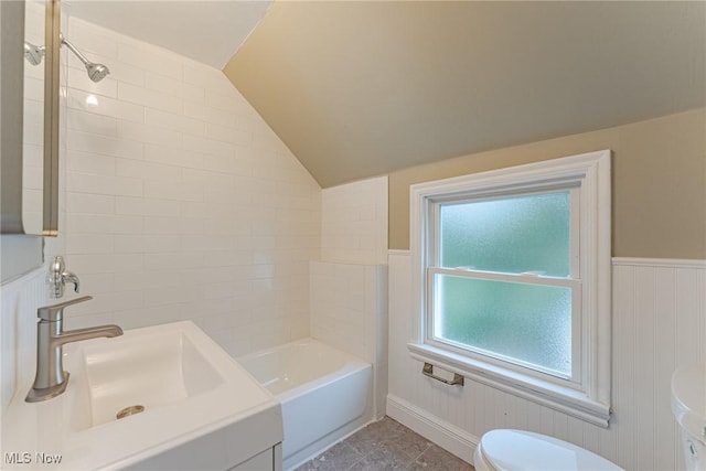 full bathroom with toilet, sink, lofted ceiling, and tiled shower / bath