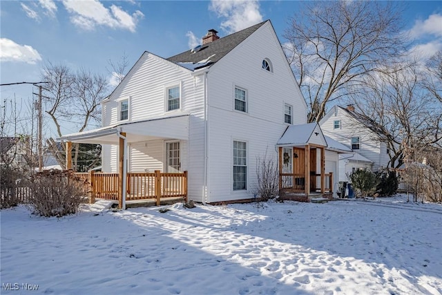 view of snow covered back of property