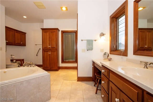 bathroom featuring tile patterned flooring, vanity, and tiled tub