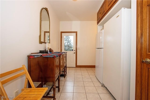 kitchen featuring white refrigerator and light tile patterned flooring