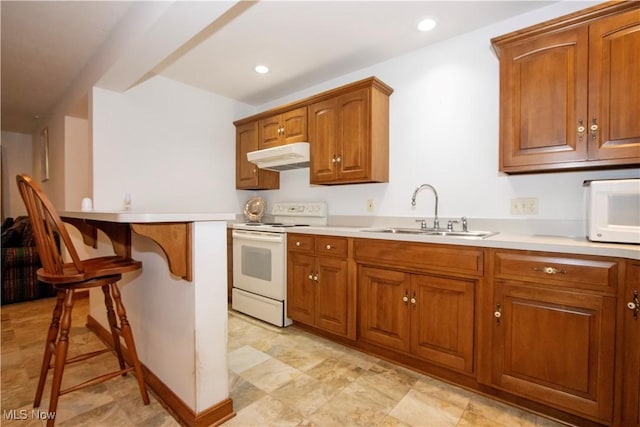 kitchen featuring a kitchen bar, sink, and white appliances