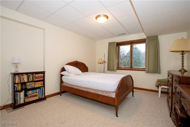 carpeted bedroom featuring a paneled ceiling