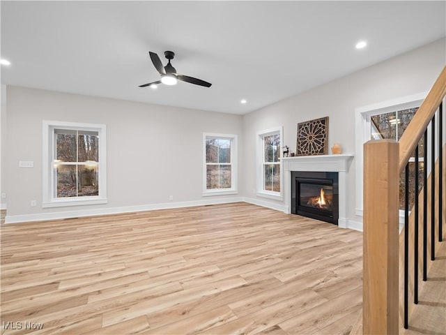 unfurnished living room with light hardwood / wood-style flooring and ceiling fan