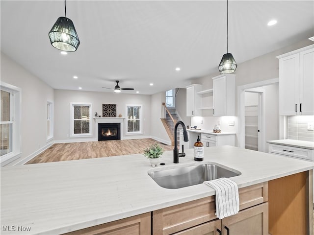 kitchen with a wealth of natural light, sink, white cabinets, and pendant lighting