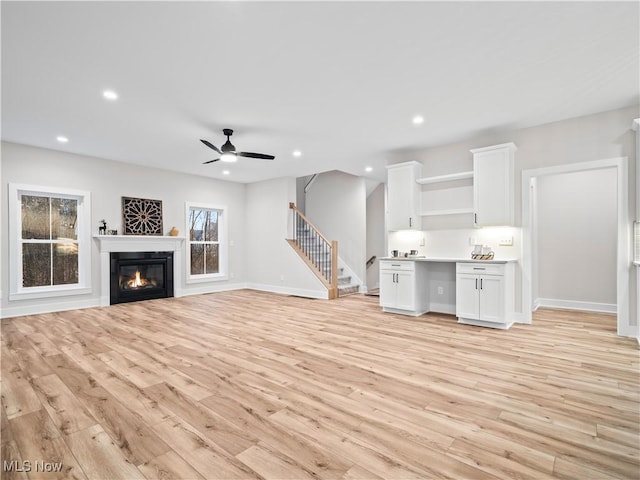 unfurnished living room with light hardwood / wood-style flooring and ceiling fan