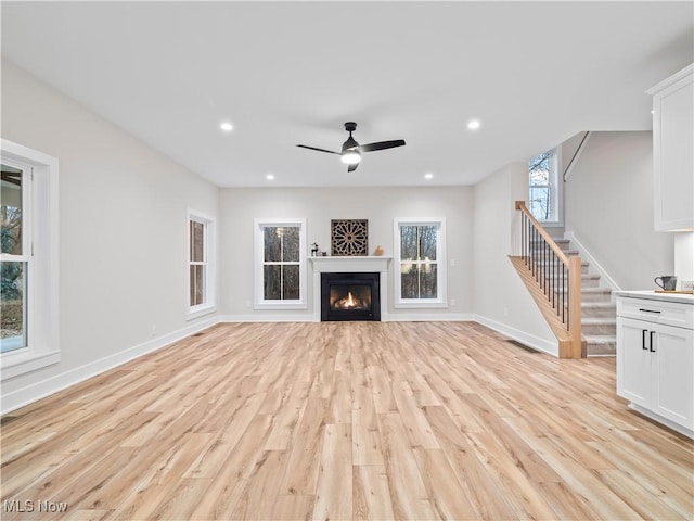 unfurnished living room featuring light hardwood / wood-style flooring and ceiling fan